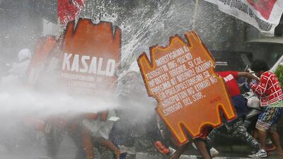 A fireman points his hose at surging protesters.