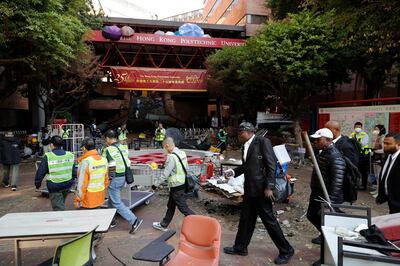 Staff members and security guards outside the entrance of Hong Kong Polytechnic University after a police siege was lifted on November 29, 2019. AP Photo