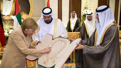 German Chancellor Angela Merkel is given the Sheikh-Zaid-Order by Sheikh Khalifa bin Zayed Al Nahyan (C), President of the United Arab Emirates, on May 25, 2010 in Abu Dhabi. Merkel arrived in Abu Dhabi on May 24 for the first leg of a four-nation Gulf tour and promptly signed a series of accords, including on hydrocarbon sector cooperation. AFP PHOTO HO BUNDESREGIERUNG/GUIDO BERGMANN GETTY OUT / AFP PHOTO / HO BUNDESREGIERUNG / GUIDO BERGMANN