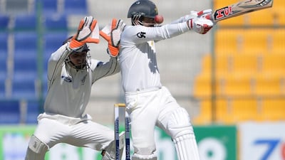 Ahmed Shahzad is hit on the helmet by a Corey Anderson bouncer as he plays a shot while New Zealand wicketkeeper BJ Watling looks on the Abu Dhabi Test. Aamir Qureshi / AFP