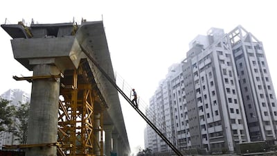 A worker climbs up to a pillar of a metro railway in Kolkata, one of the infrastructure projects being undertaken in India. Rupak De Chowdhuri / Reuters