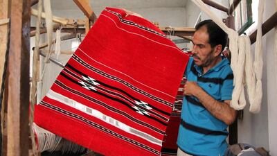 Syrian weaver Abu Mohammad displays an unfinished carpet at a workshop in the village of Ariha, on the southern outskirts of Syria’s rebel-held Idlib province, on the last day of weaving before the workshop was forced to close because of a lack of thread imported from conflict-ridden Aleppo. Omar Haj Kadour / AFP