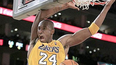 Kobe Bryant, left, slam dunks into the Phoenix basket.