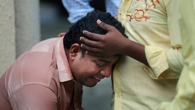 An Indian man mourns outside a morgue in Mumbai on September 29, 2017 for a relative killed in the stampede at the Parel and Elphinstone stations. Rafiq Maqbool / AP