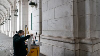 A worker prepares to cover swastikas drawn on the front of Union Station. AP