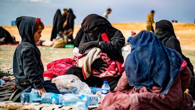 Dorothee Maquere, the wife of French ISIS member Jean-Michel Clain, sits with four of her five children at a screening area in the eastern Syrian province of Deir Ezzor. AFP