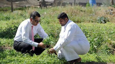Puneet Singh, the general manager of the Kempinski Grand & Ixir Hotel, Bahrain, inspects produce with a local farmer. Phil Weymouth for The National