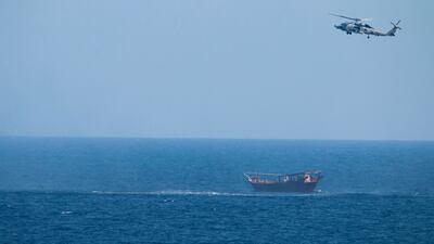 A US Navy Seahawk helicopter flies over a stateless dhow later found to be carrying a hidden arms shipment in the Arabian Sea, in May 2021. AP