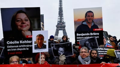 Supporters and relatives of French citizens detained in Iran gather in front of the Eiffel Tower during a rally demanding their release, in Paris. Reuters