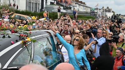 Crowds line the street as the hearse carrying Sinead O'Connor's coffin passes by her former home in Bray. Getty Images