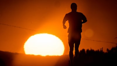 A man runs at sunrise on a small road on the outskirts of Frankfurt. AP
