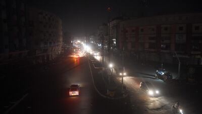 Motorists drive through a residential area during a power blackout in Pakistan's port city of Karachi. AFP