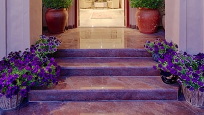 The curved entrance went against the client's first love of lines, but the designer brought it into place with symmetrical planting. The dramatic entrance lighting with precision-cut foliage also sets an inviting scene