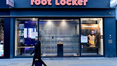 A woman walks past a closed footwear shop in Berlin on Friday. EPA