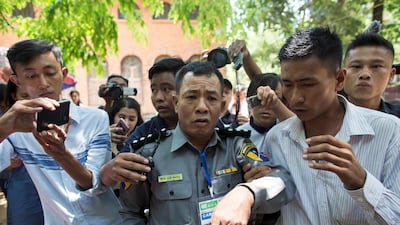 In this photo, taken on April 20, 2018, Myanmar deputy police major Moe Yan Naing (C) leaves the court following the ongoing trial of two detained journalists in Yangon. Sai Aung Main / AFP