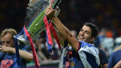 Barcelona's Luis Suarez celebrates with the trophy after the Uefa Champions League Final final against Juventus at the Olympic Stadium in Berlin on June 6, 2015. Barcelona won the match 3-1. AFP PHOTO / OLIVER LANG