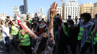 People wave Lebanese flags and chant to mark the first anniversary of anti-government protests. Getty Images