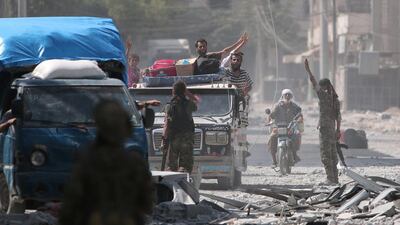 Syria Democratic Forces fighters greet civilians who were evacuated from an ISIL-controlled neighbourhood of Manbij in Aleppo province on August 12, 2016. The SDF said ISIL abducted 2,000 residents of the town to use as human shields. Rodi Said / Reuters