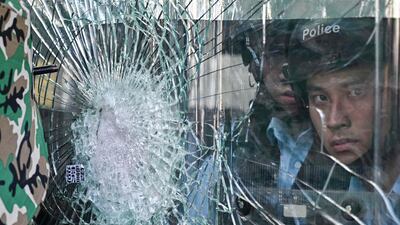 Police standing inside the government headquarters look at protesters who tried to smash their way into the building. AFP