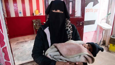 A Syrian woman holding a child waits at a makeshift clinic at the camp for the displaced in al-Hasakeh governorate in northeastern Syria. AFP