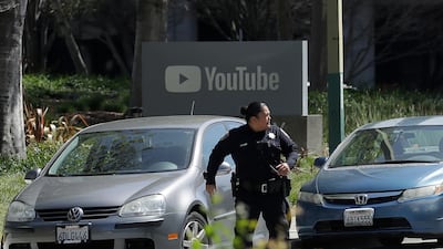 An officer runs past a YouTube sign near the company's complex in San Bruno. Four people were wounded before the shooter killed herself, police and witnesses said. AP Photo/Jeff Chiu