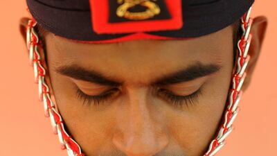A Sri Lankan Army personnel stands guard during the cremation ceremony for senior monk Galagama Attadassi, 94, during his funeral in Kandy. Sri Lanka has declared a day of mourning after one its most senior Buddhist monks died. Lakruwan Wanniarachchi / AFP