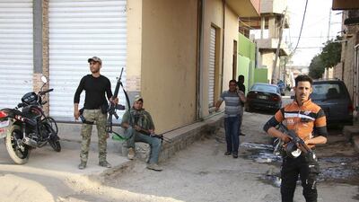 Sunni tribal fighters carry their weapons as they stand guard against attacks from ISIL militants in Ramadi on May 15. Reuters