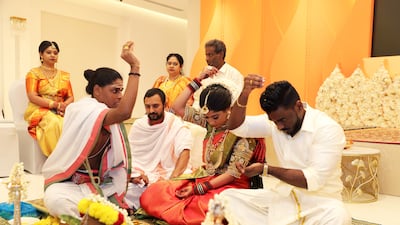 A priest explains prayers and rituals to the bride Iswarya Sundararajan and groom Arvindh Selvam during their marriage ceremony at the Hindu temple in Jebel Ali, Dubai. All photos: Pawan Singh / The National