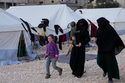 Women and children walk in a camp in Atareb, Syria, after losing their homes in the earthquake. AP