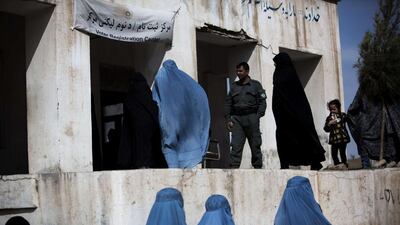 Afghan residents queue to receive their voter cards for the upcoming presidential election at a voter registration centre in Herat. Behrouz Mehri / AFP
