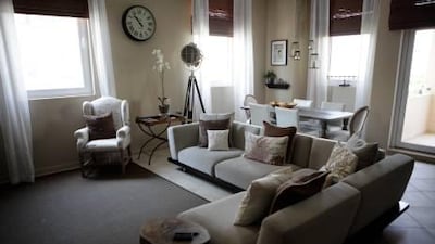 The living room's monotone colour palette creates a calm atmosphere, while textures and natural elements such as a petrified wood side table add warmth and homeliness. Sammy Dallal / The National