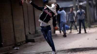 A protester throws a stone towards Indian police during a protest against the recent killings in Kashmir, in Srinagar. Danish Ismail / Reuters