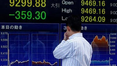 A passer-by watches an electronic stock indicator in Tokyo. Asian stock markets tumbled Friday amid fears the U.S. may be heading back into recession and Europe's debt crisis is worsening. (AP Photo/Shizuo Kambayashi)