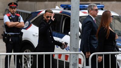 Neymar waves as he leaves after attending the opening audience at the courthouse in Barcelona. AFP
