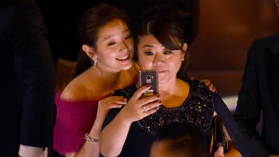 Park So-dam, left, and Lee Jeong-eun take a selfie as they appear on stage to accept the award for best picture for ‘Parasite’ at the Oscars on Sunday, February 9, 2020. AP