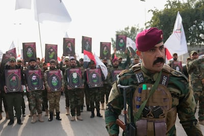 Members of an Iraqi Shiite militant group attend a funeral for the group members who were killed by a US air strike, in Baghdad on Sunday. AP
