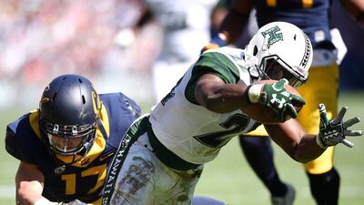 Diocemy Saint Juste, right, of the Hawaii Rainbow Warriors scores a touchdown during the Sydney college American football game. Paul Miller / EPA