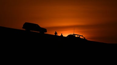Tourists and residents watch the sunset in Sealine, south of Doha, Qatar. AFP