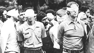 Blindfolded US hostages and their Iranian captors outside the US embassy in Tehran in 1979. US Army via Reuters