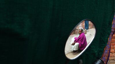 Cured leprosy patient Bhangarauva, 60, is seen in the reflection of a side mirror on a motorbike.