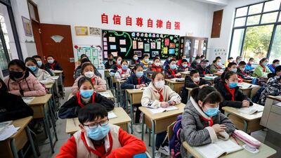 Elementary school students wearing face masks attend a class as they return to school after the start of the term was delayed in Huaian in China's eastern Jiangsu province. AFP