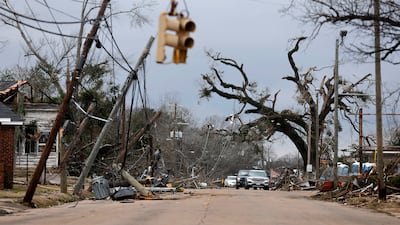 Cars carefully navigate downed trees and power lines on in Selma. AP