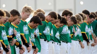 Santa Fe High School baseball players bow their heads in a moment of silence for the shooting victims at their school before a baseball game against Kingwood Park High School in Deer Park, Texas, Saturday, May 19, 2018. (AP Photo/David J. Phillip)