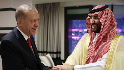 Mr Erdogan (L) shakes hands with Prince Mohammed. AFP