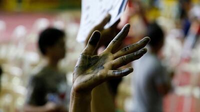 A drug user raises his ink smeared hand after he surrendered to local government officials to take part in a government campaign against drugs in Tanauan Batangas, south of Manila, Philippines. Erik De Castro / Reuters