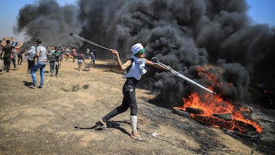 Palestinian protesters hurl stones at Israeli troops during a protest on the Gaza Strip's border with Israel, Monday, May 14, 2018. On the border with Gaza, at least 58 Palestinians were killed, marking the deadliest day of the demonstrations since late March. Wissam Nassar