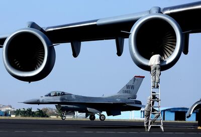 A Lockheed Martin F-16 fighter jet behind a US Air Force C-17 Globe Master. EPA