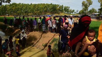 Rohingya refugees cross a small bridge at Kutupalong refugee camp in Bangladesh's Ukhiya district on September 9, 2017. Nearly 300,000 Rohingya Muslims have fled Myanmar's Rakhine state into Bangladesh in the 15 days since new violence erupted, the United Nations said September 9. The figure has jumped about 20,000 in a day. Munir Uz Zaman / AFP
