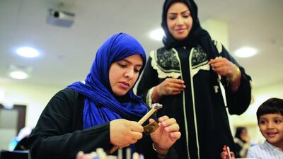 Azza Al Qubaisi, above left, leads an Islamic jewellery-making class at the Sharjah Museum of Islamic Civilization.