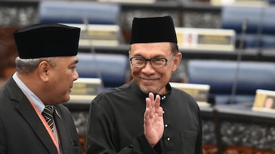 Malaysia's People's Justice Party president and leader of the Pakatan Harapan coalition Anwar Ibrahim waves before taking an oath as a member of the parliament during a swearing-in ceremony at the Parliament House in Kuala Lumpur. AFP